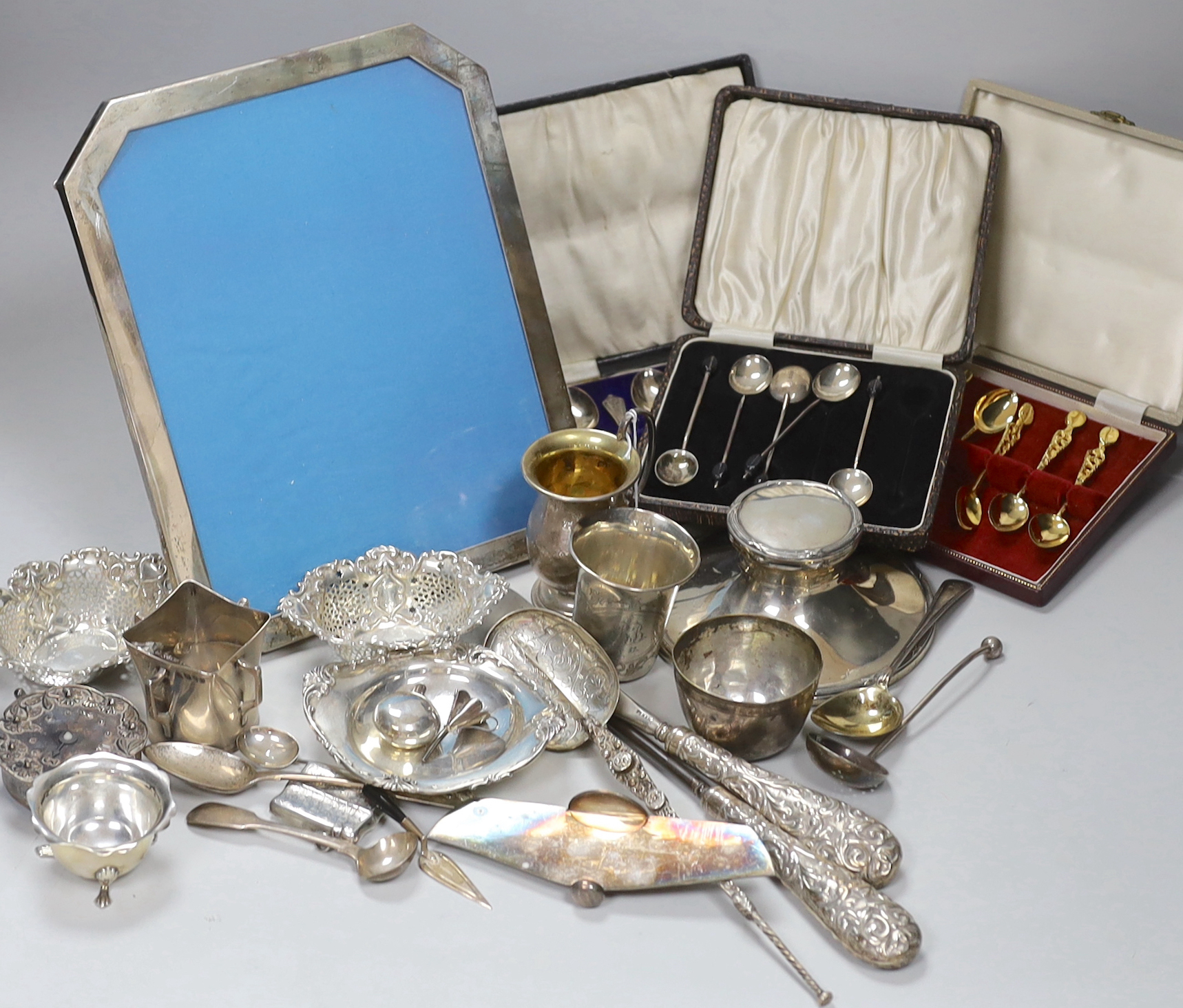 Assorted silver and white metal items including capstan inkwell, mug, photograph frame, cased and loose flatware, anointing spoon replica, beakers etc.